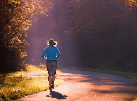 woman runs down trail
