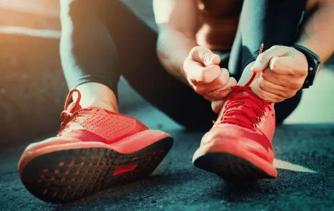 person lacing up an athletic shoe